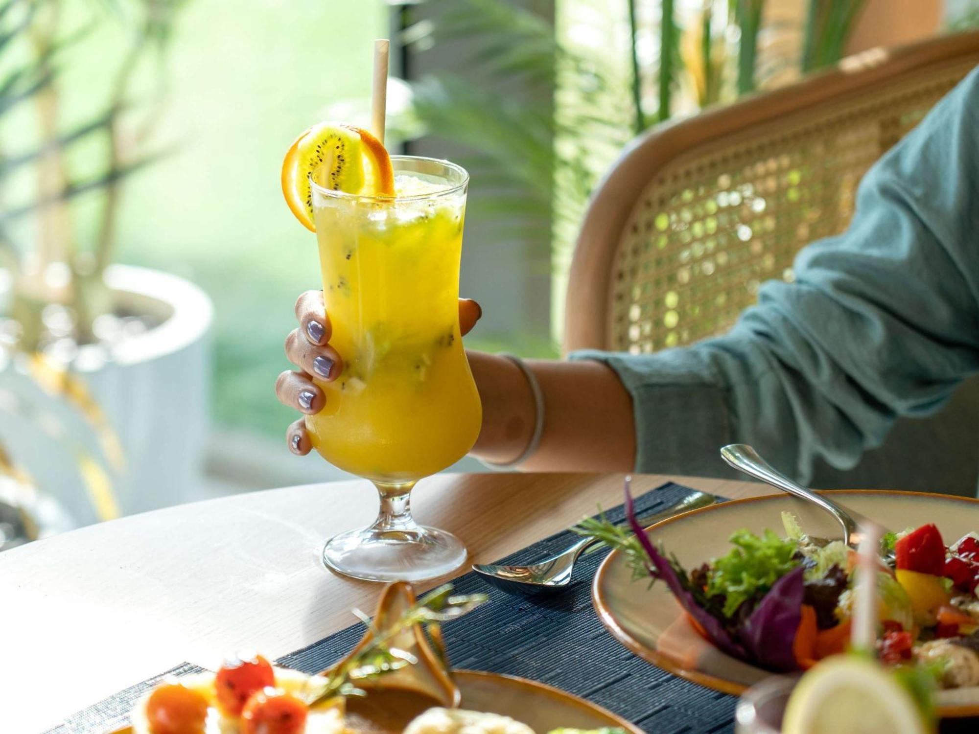 Swissotel Living Dschidda Exterior foto A woman holding a glass of juice